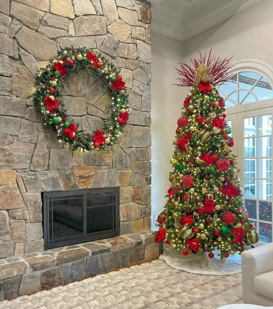 Christmas tree and wreath beside stone fireplace