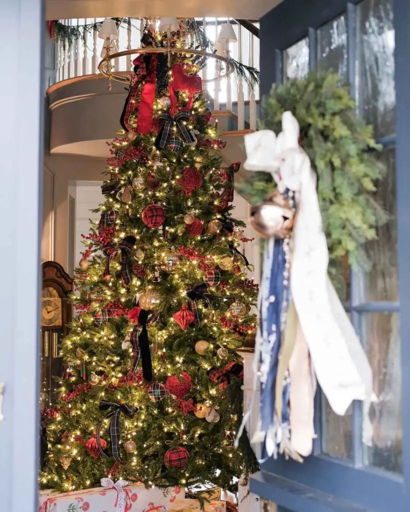 Elegant Christmas tree adorned with tartan plaid ribbons gold ornaments and red berries