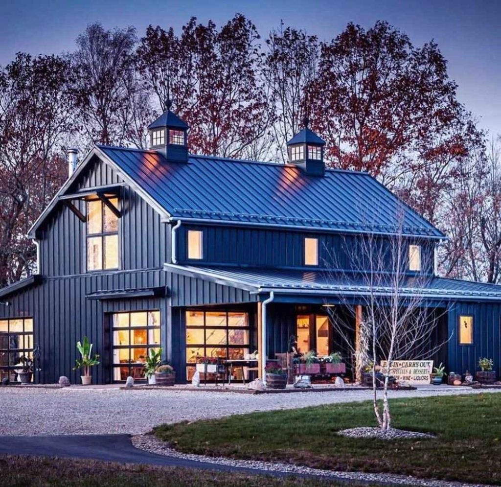 Stylish gray barn shop with glowing windows and retail space at sunset