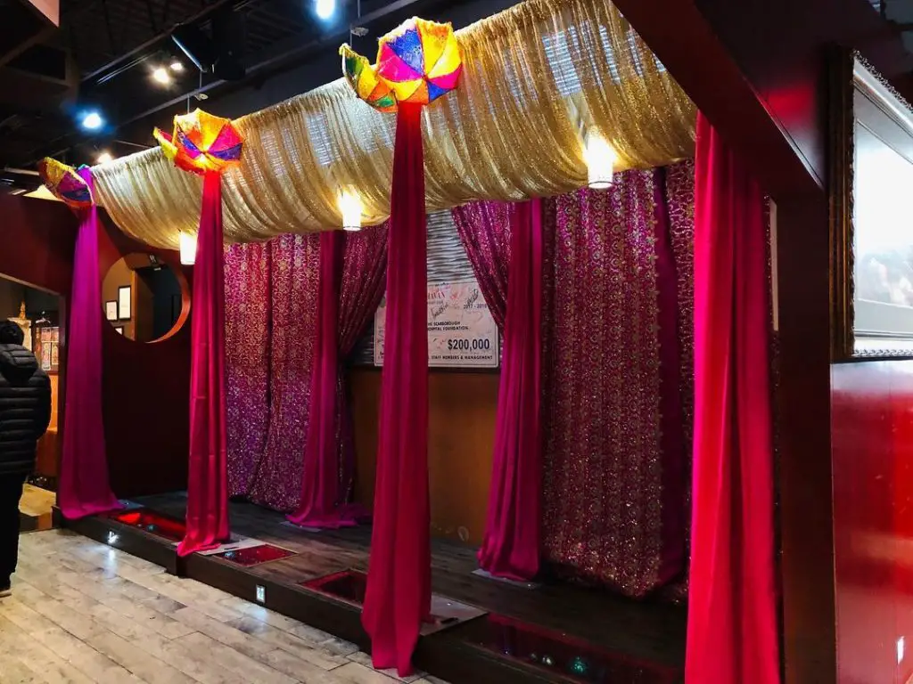 Colorful wedding canopy with gold drapes and umbrellas