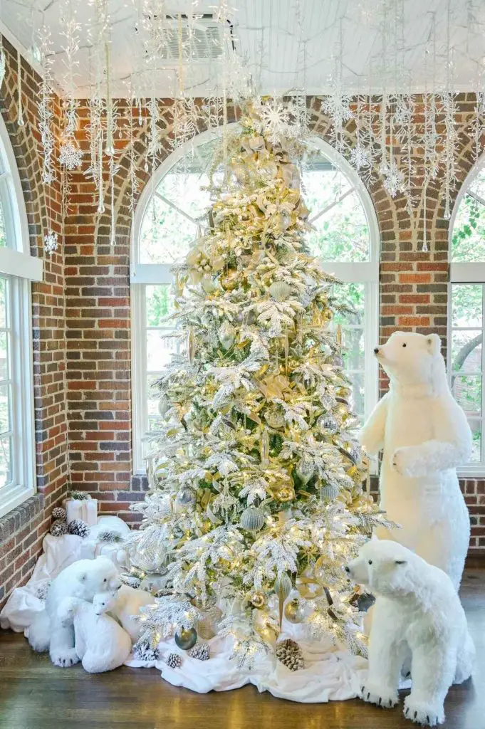 Frosty white Christmas tree with polar bear decorations in sunroom