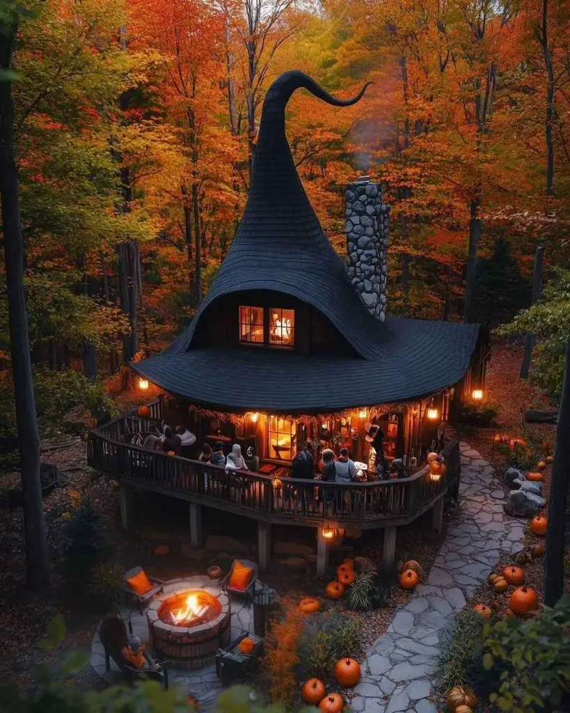 Witch hat-shaped cottage hosts autumn gathering in colorful forest.