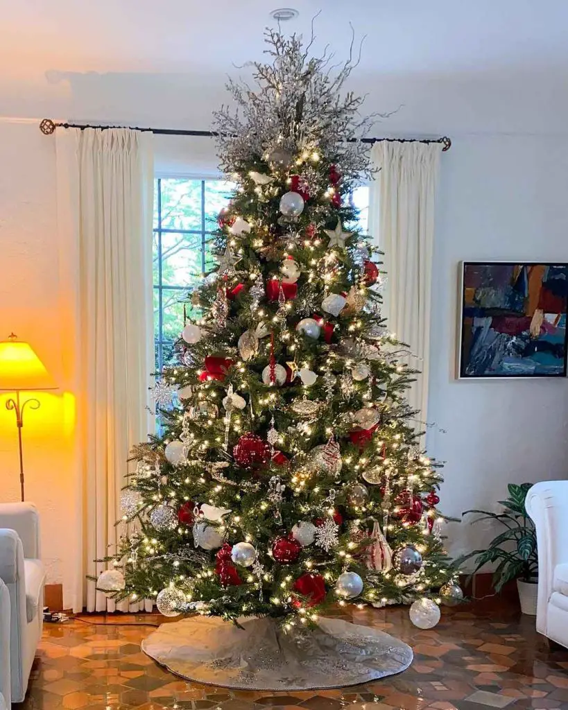 Tall Christmas tree with red and silver decorations snowflake ornaments and warm lighting