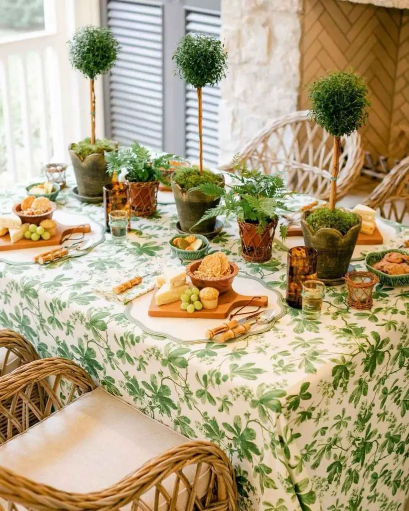 Garden-themed tablescape with topiaries cheese boards and leafy tablecloth