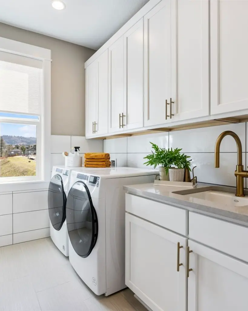 Bright white laundry room gold hardware mountain view window