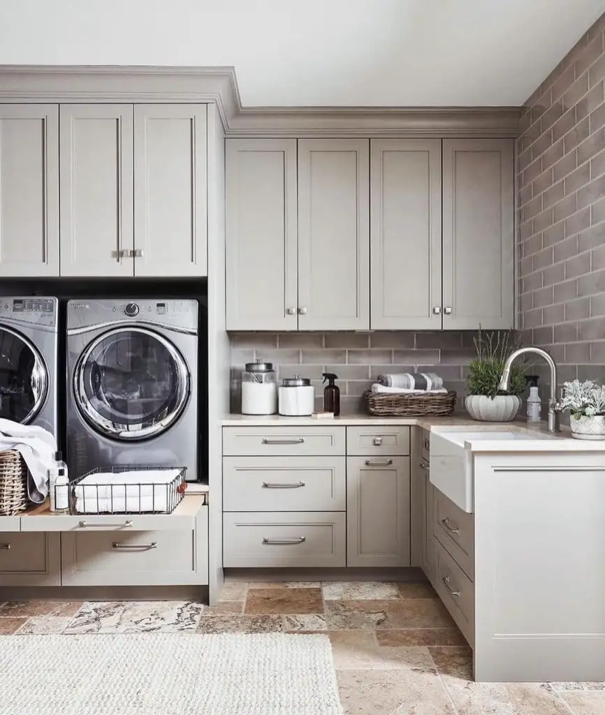 Sophisticated gray laundry room with stone floors and subway tile
