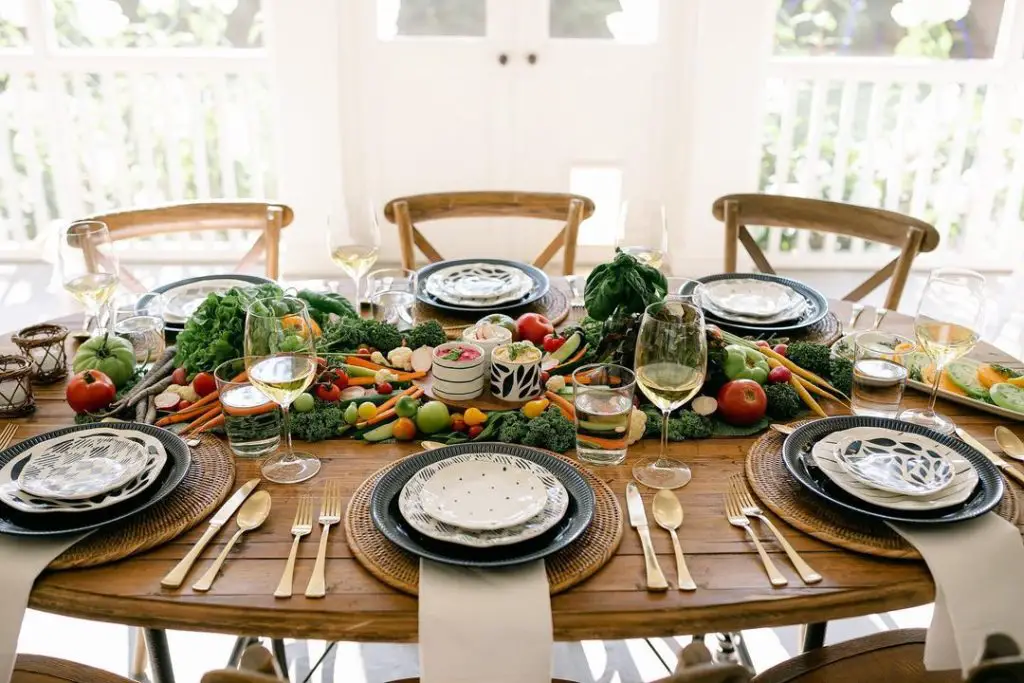 Farmhouse table setting with fresh vegetable centerpiece and navy patterned plates