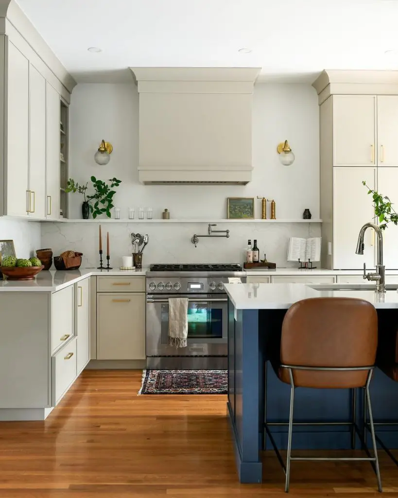 Elegant cream kitchen with brass details and leather barstool