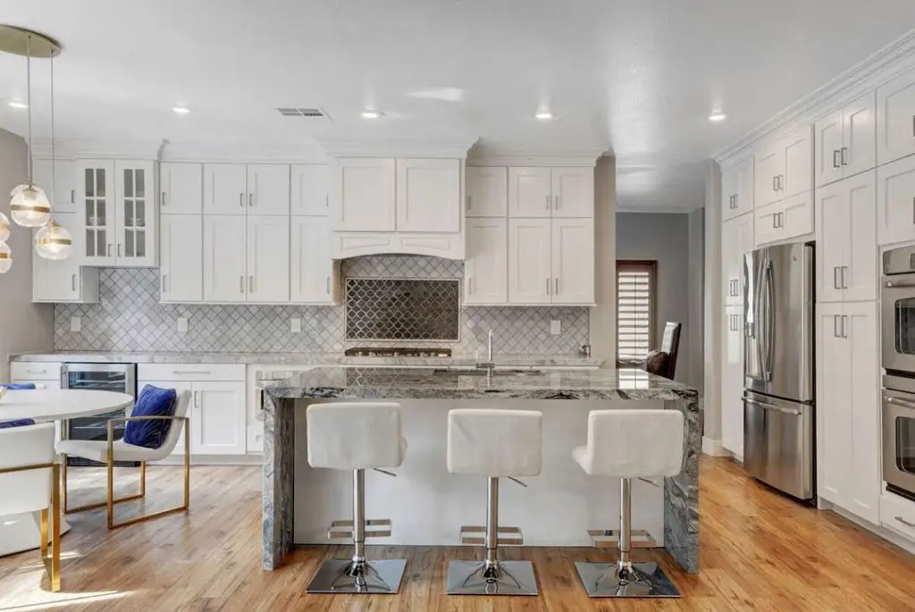 Elegant white kitchen with marble waterfall island