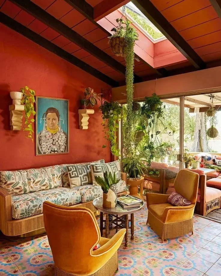 Sunroom with terracotta walls hanging plants skylight and vintage furniture on colorful Mexican tiles