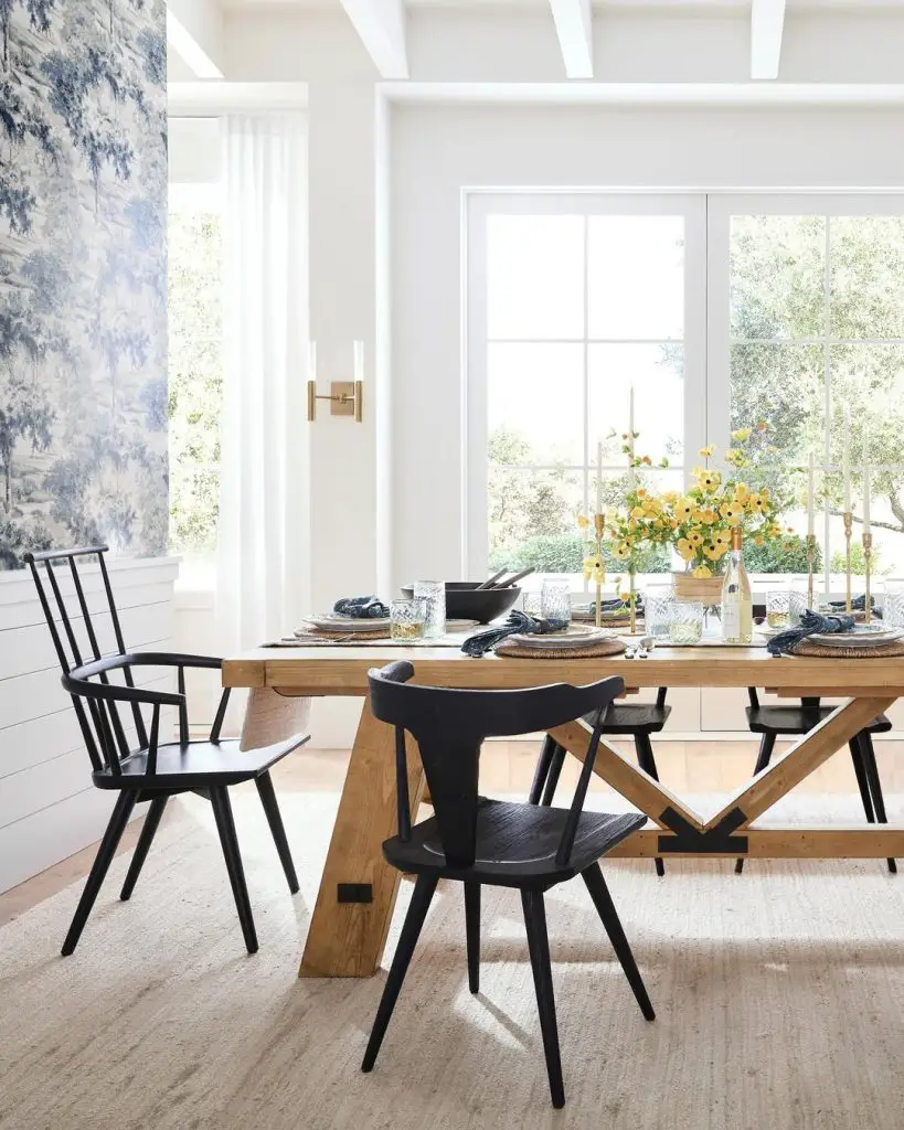Modern farmhouse dining room with black chairs oak table and yellow floral centerpiece