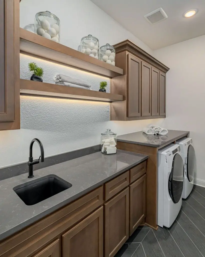 Luxury laundry room brown cabinets lighted floating shelves grey countertops
