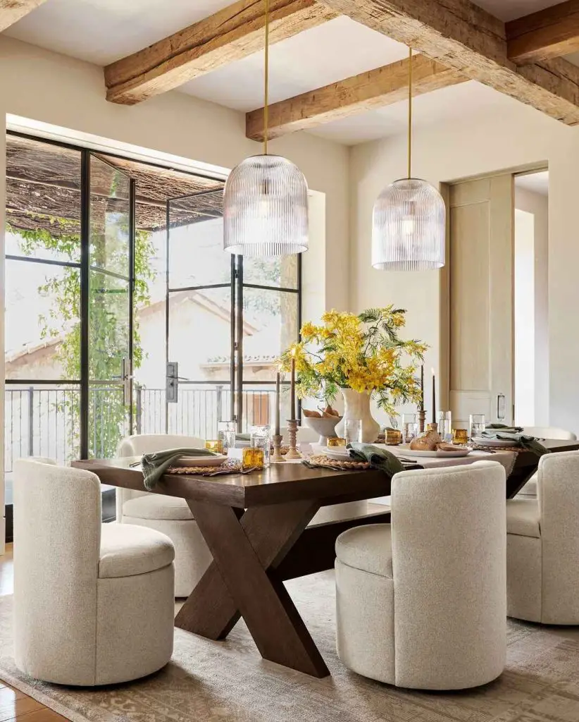 Bright dining room with cream chairs wooden table and yellow flowers