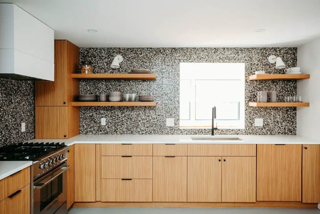 Wooden kitchen cabinets with speckled terrazzo wall design