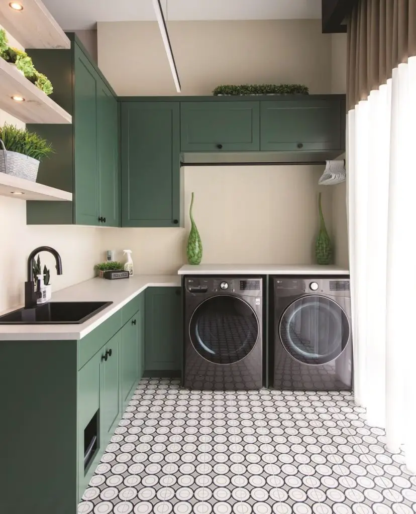 Modern sage green laundry room with patterned floor tiles and floating plant shelves