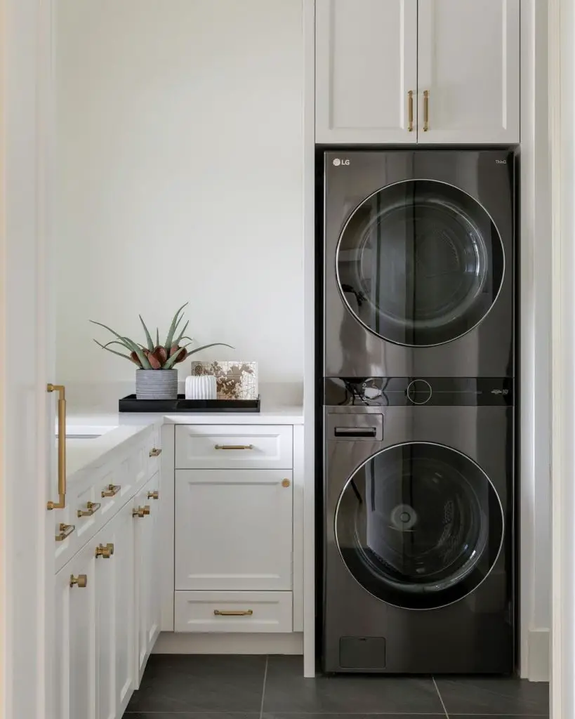 Compact white laundry room with gold hardware