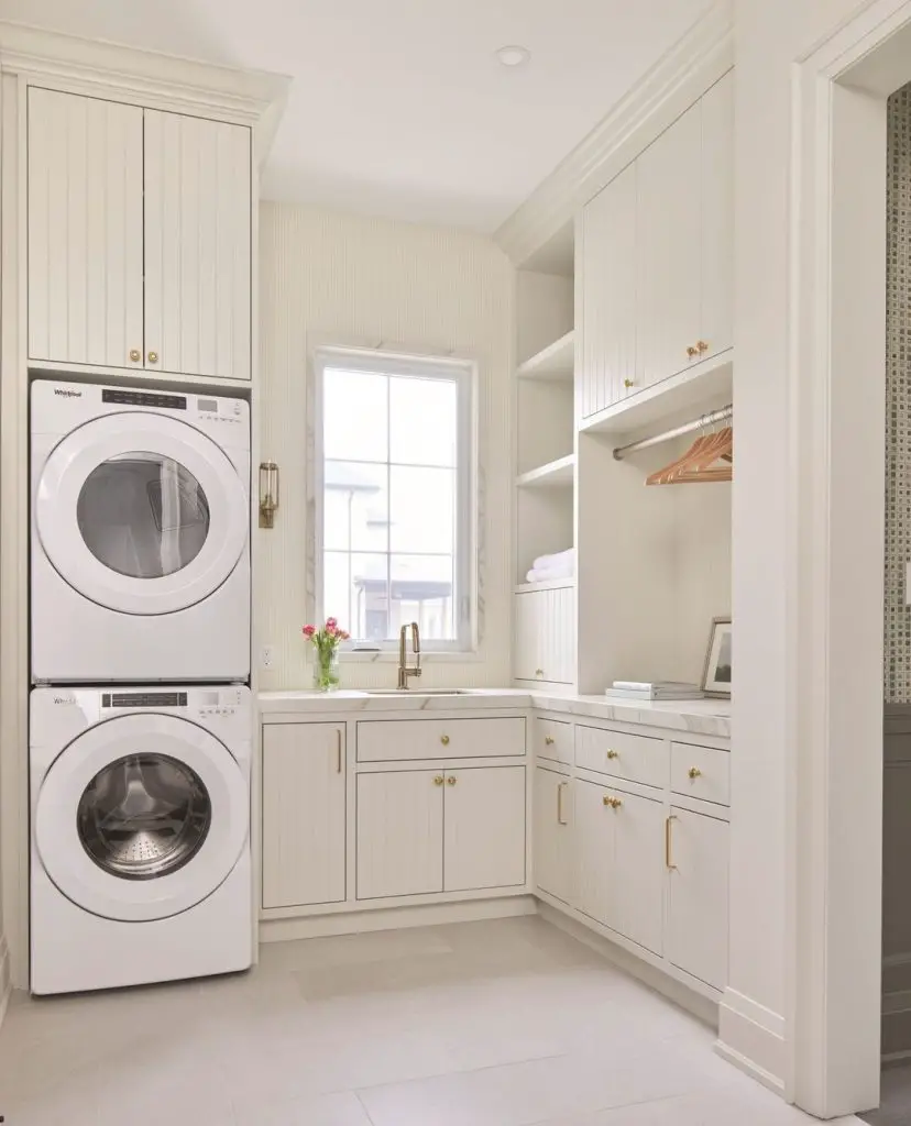 Modern white laundry room with stacked appliances and built-in storage