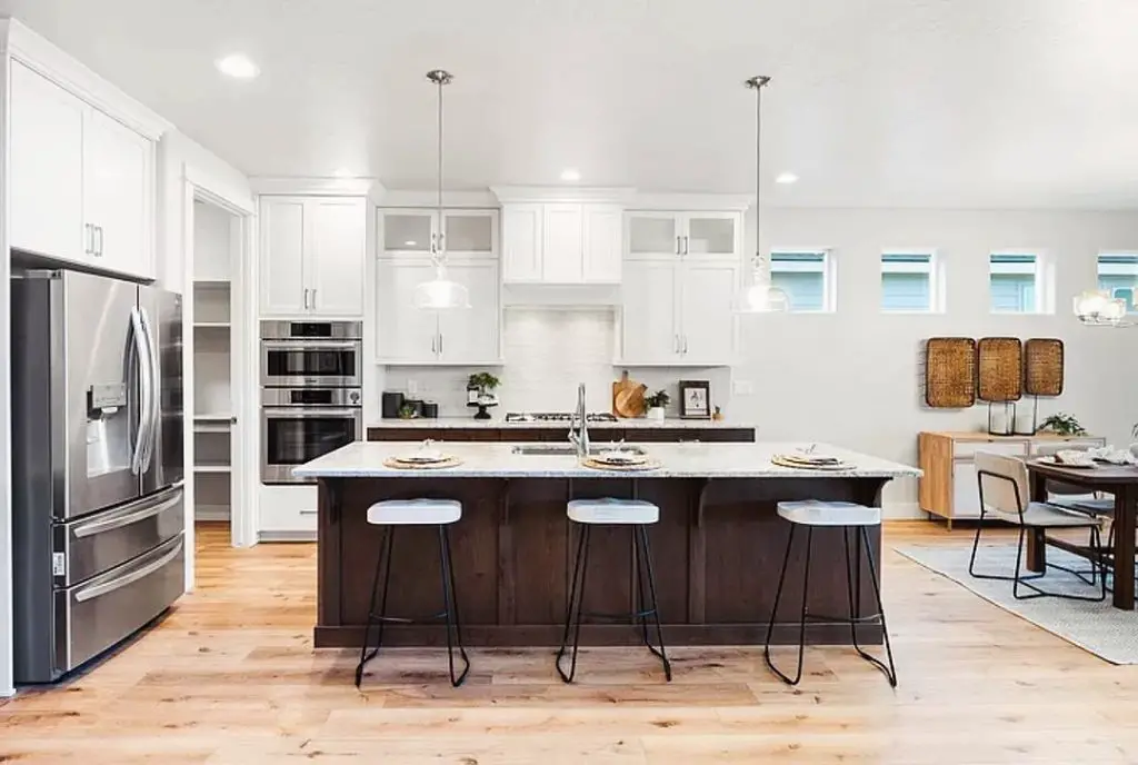 Bright modern kitchen with white cabinets and blue barstools