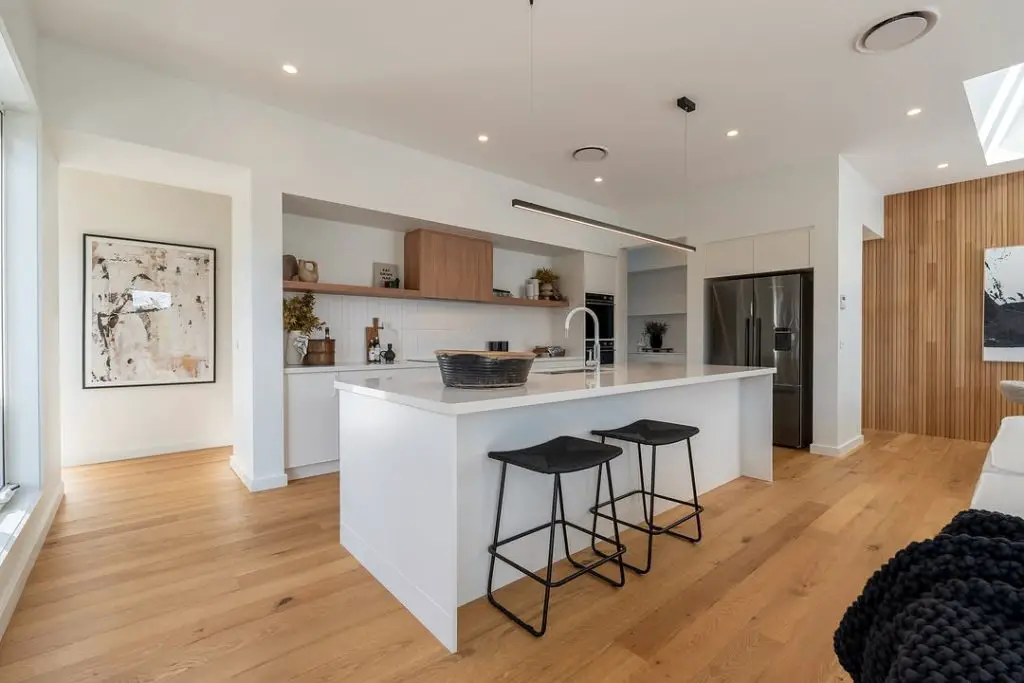 Clean white kitchen with wooden floor accents