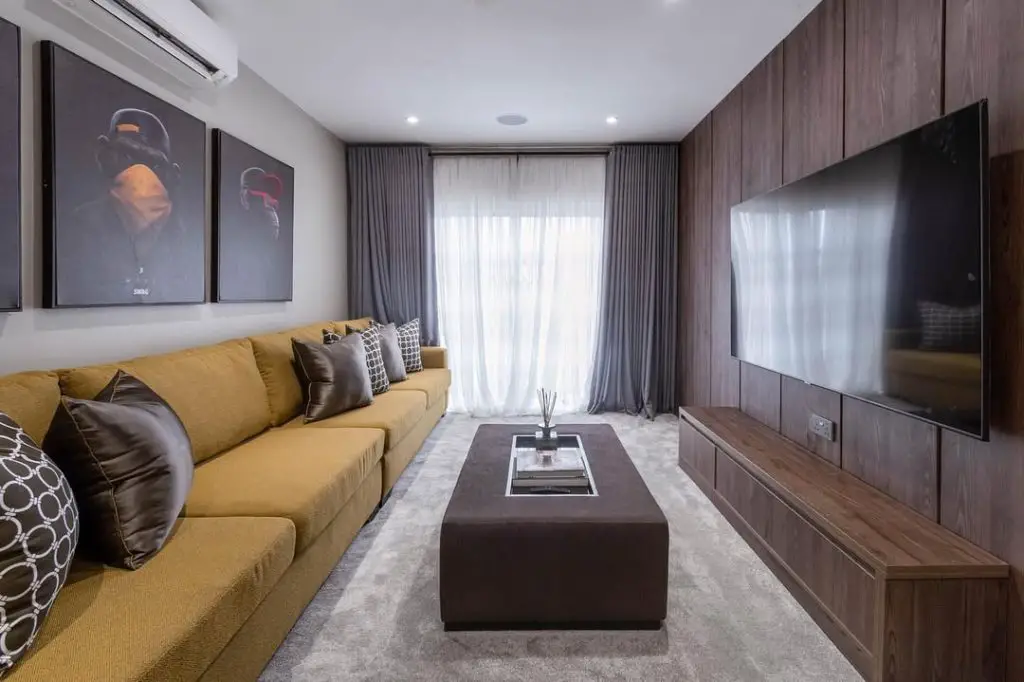 Basement TV room with electric fireplace.