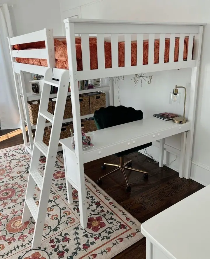 White loft bed with full-width desk and vintage floral rug underneath