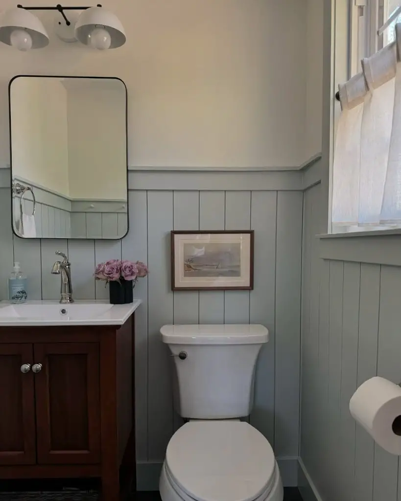 Powder room with gray palm print wallpaper and blue heron artwork