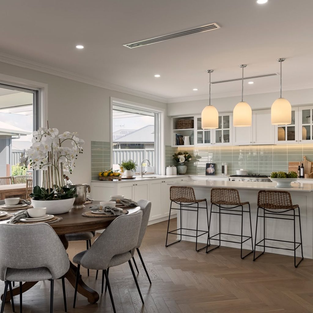 Bright kitchen dining space with sage backsplash and rattan barstools