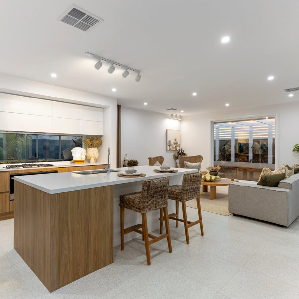 Bright coastal kitchen with white cabinets and woven bar chairs