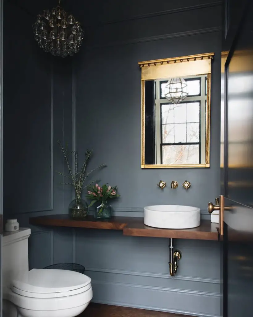 Modern powder room with dark walls crystal chandelier and floating wood vanity