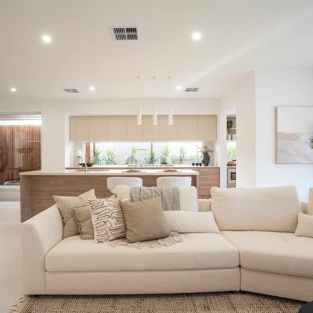 Minimalist beige living space with cream sectional and wooden accents