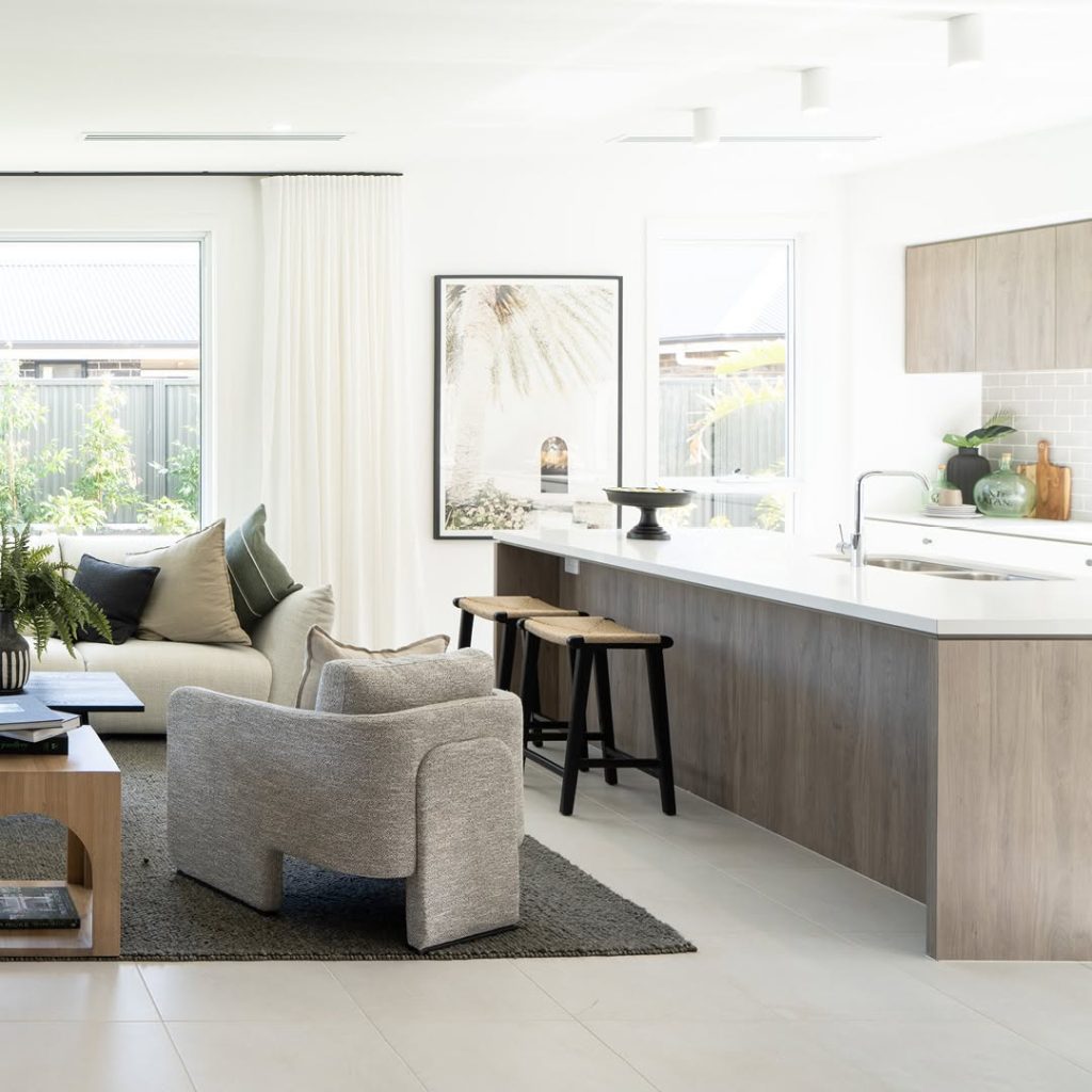 Modern open concept living room with kitchen featuring neutral tones and clean lines