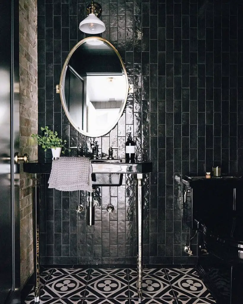 Dark tiled powder room with floating sink and patterned floor tiles