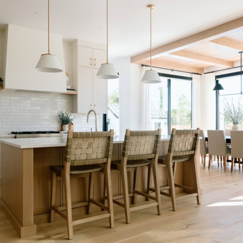 Bright coastal kitchen with woven bar stools and pendant lighting