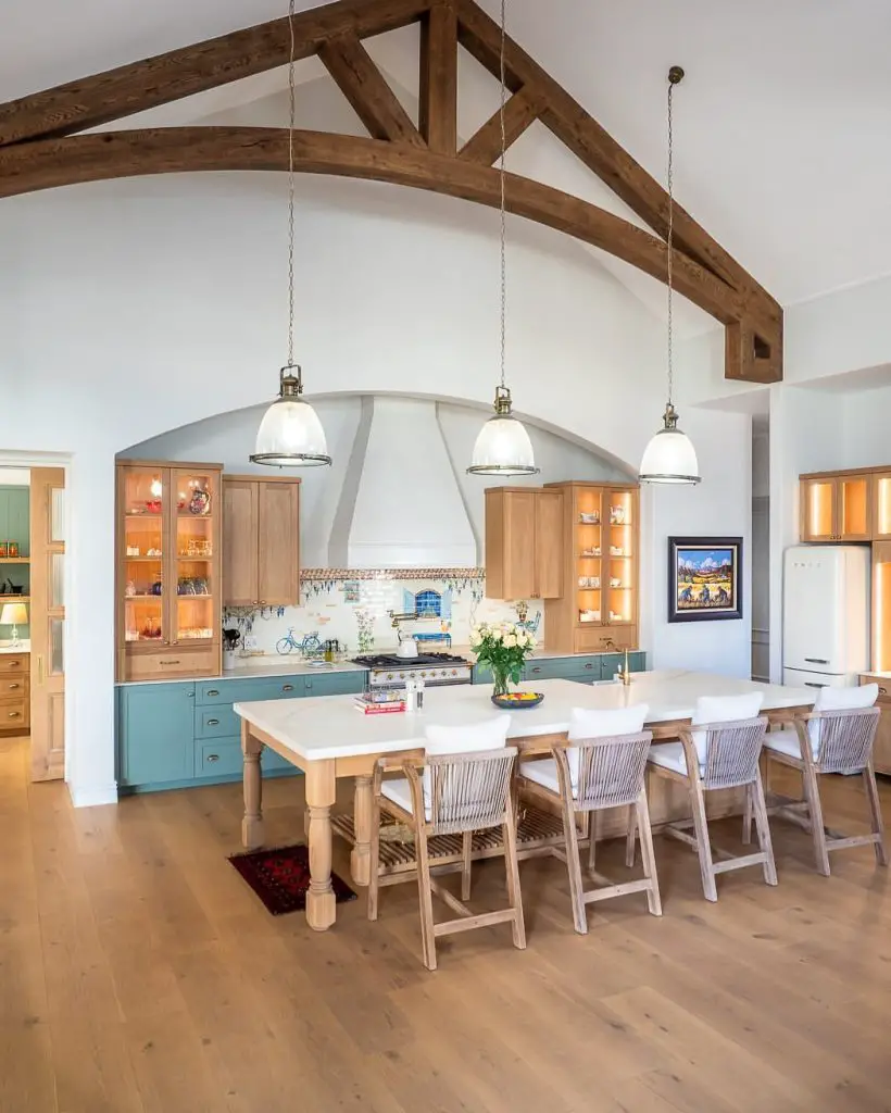 Coastal kitchen featuring exposed beams and sage blue cabinetry