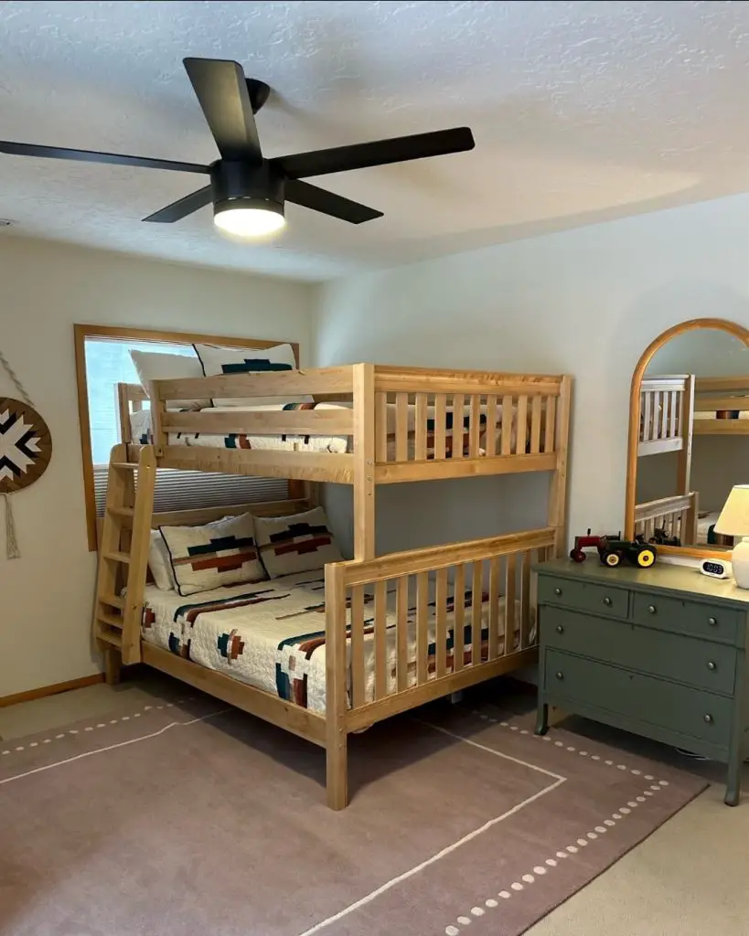 Wooden bunk bed with quilted bedding black fan and green dresser