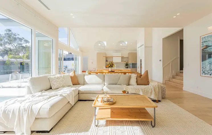 Bright coastal living room connecting to modern kitchen space