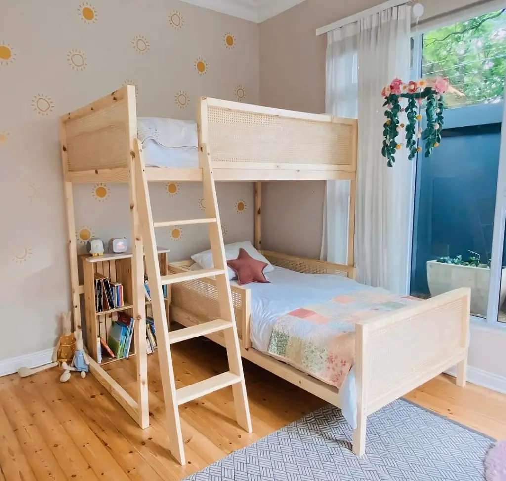 Light wood bunk bed with cane details sun wallpaper and hanging flowers