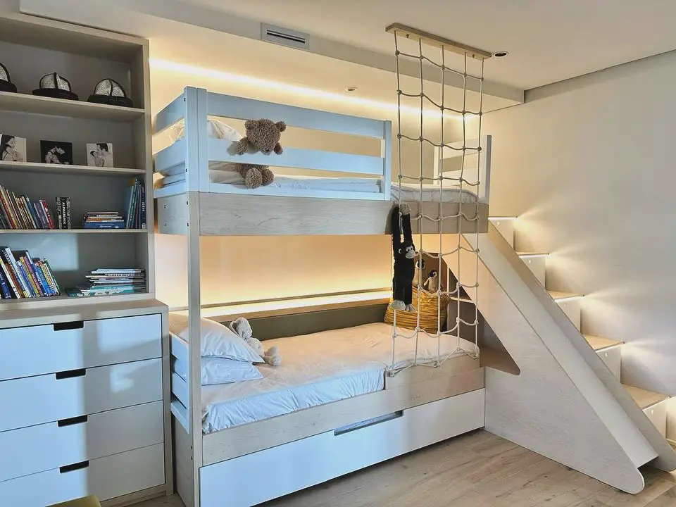 White bunk bed with slide storage drawers and climbing rope wall