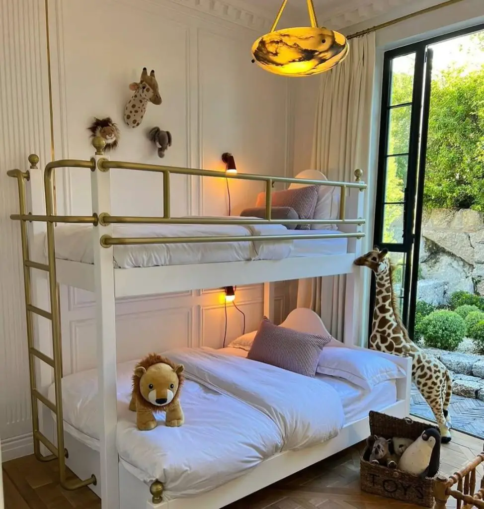 White bunk bed with brass rails safari decor and amber lighting