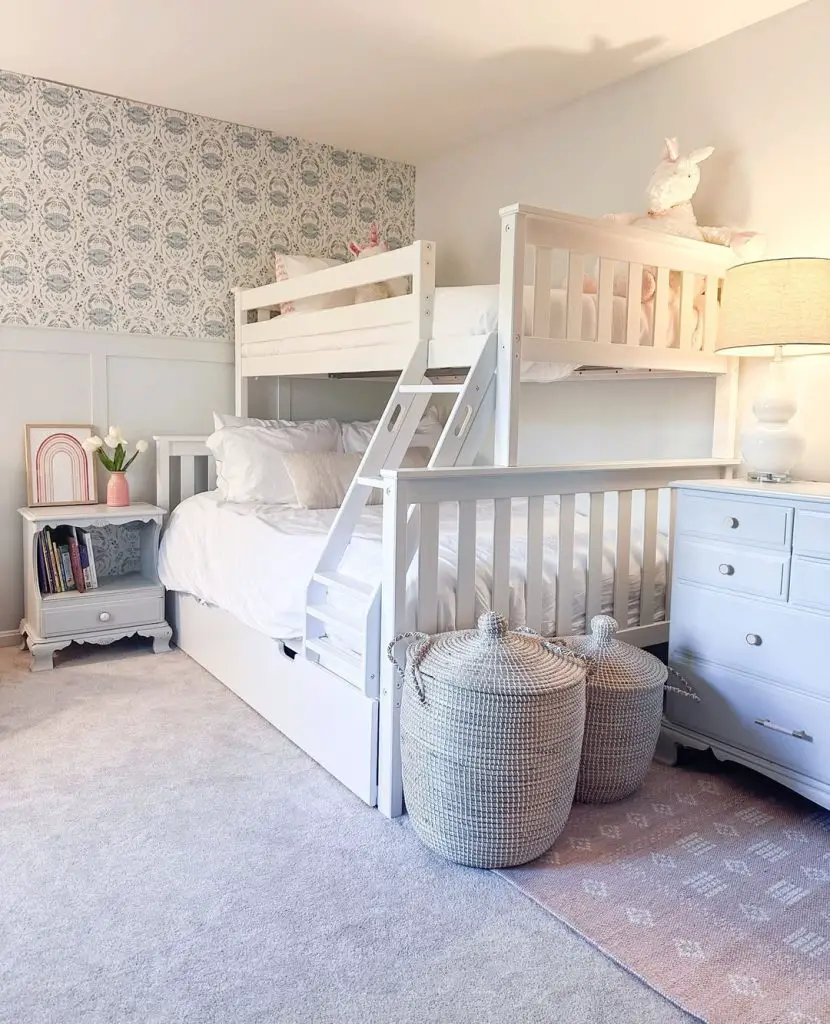 White loft bed with gray wallpaper and storage baskets in a cozy kids room.