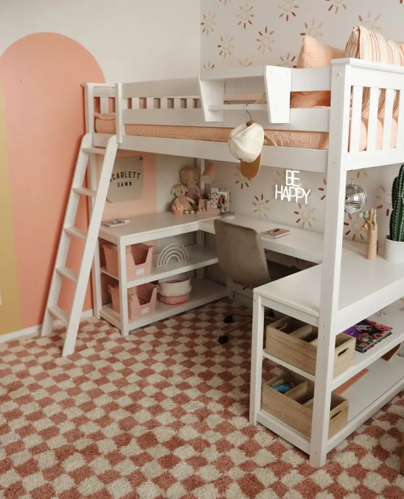 White loft bed with pink walls desk area and organized storage underneath.