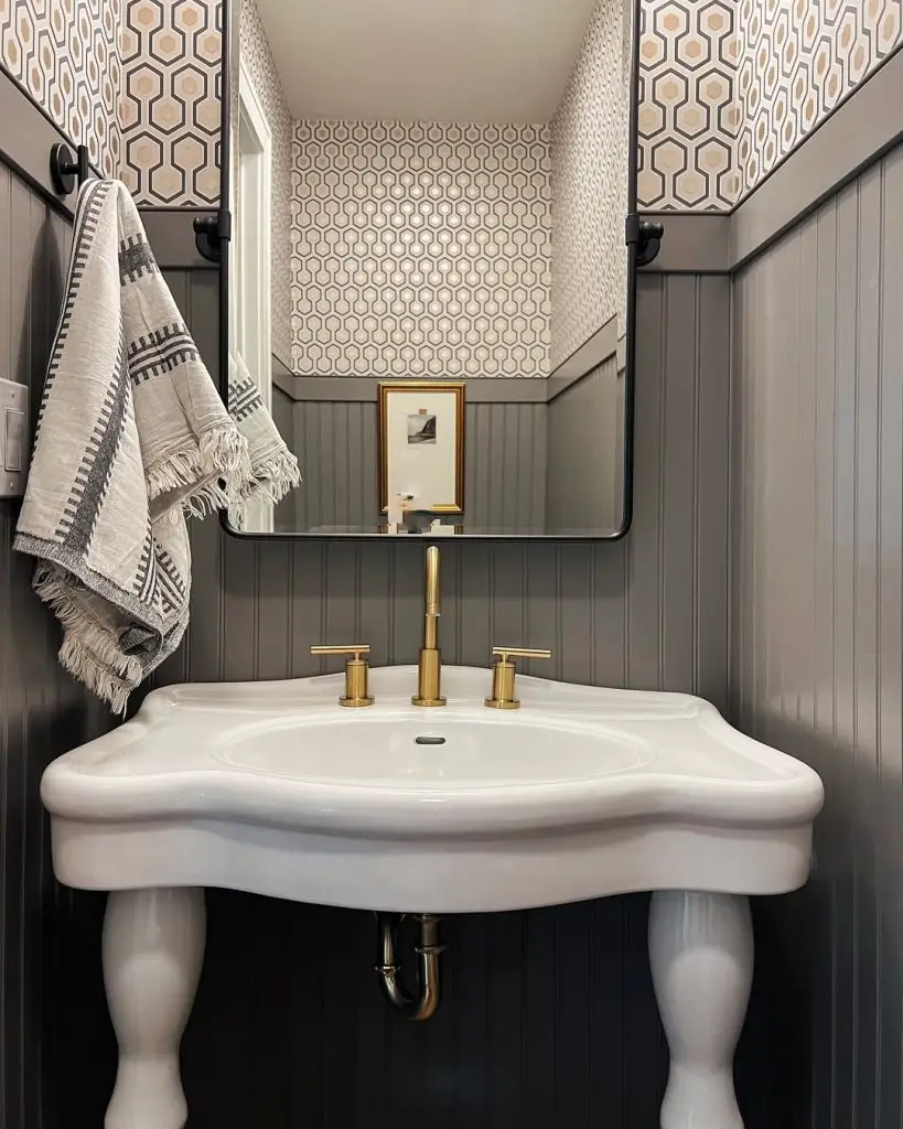 Gray powder room with hexagon wallpaper and pedestal sink