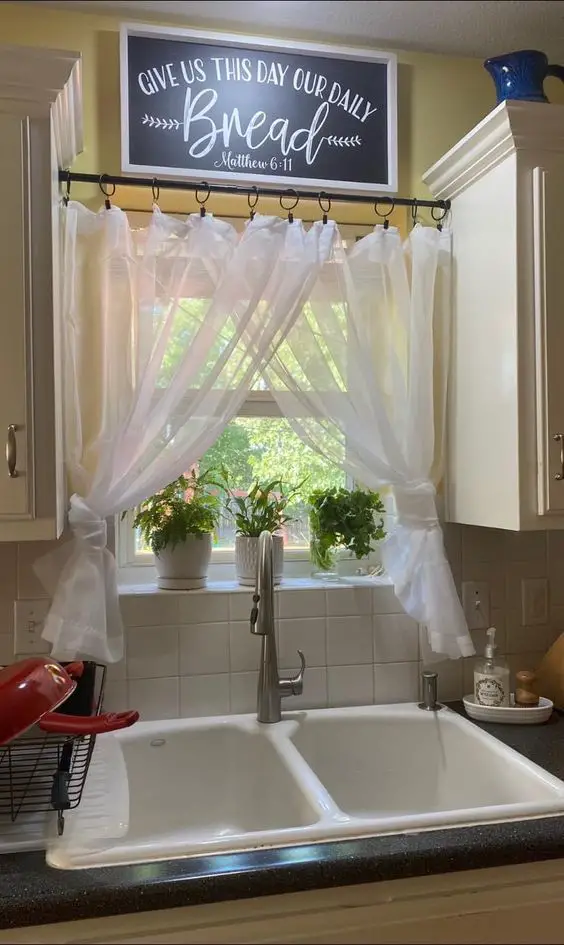 Bright kitchen with farmhouse sink, sheer curtains, and inspirational sign