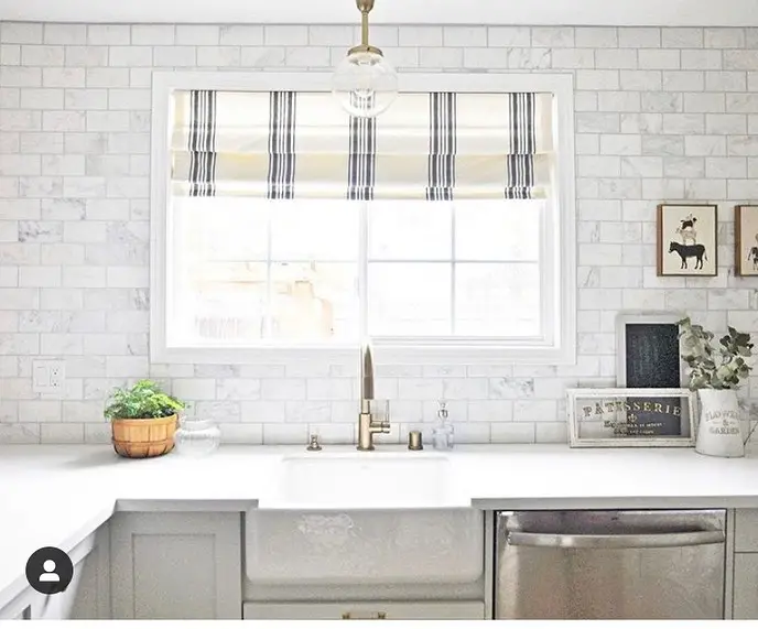 Bright kitchen with marble backsplash and striped valance