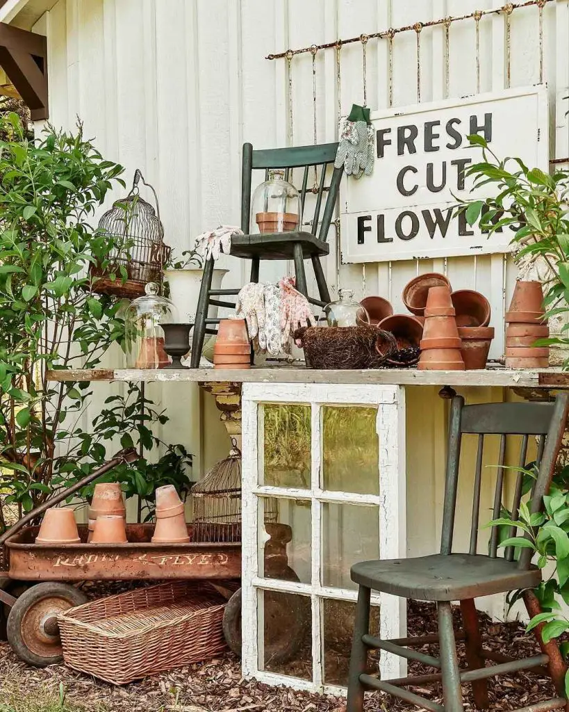 Garden stand with terracotta pots, gloves, and a vintage chair
