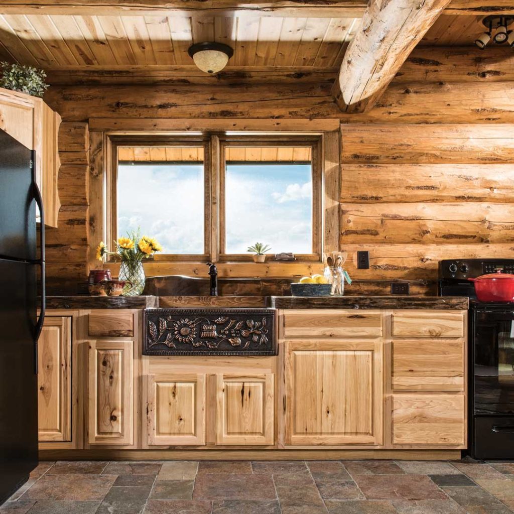 Rustic kitchen with log walls and wooden cabinets