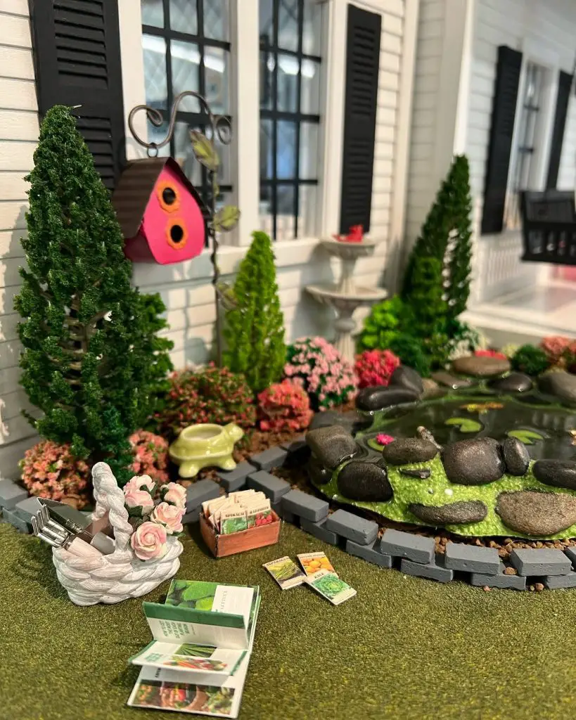 Miniature garden with a pond, birdhouse, and gardening tools