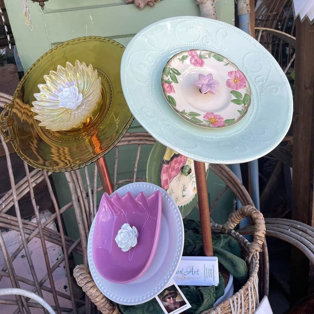 Decorative garden stakes with colorful glass plates in a woven basket.