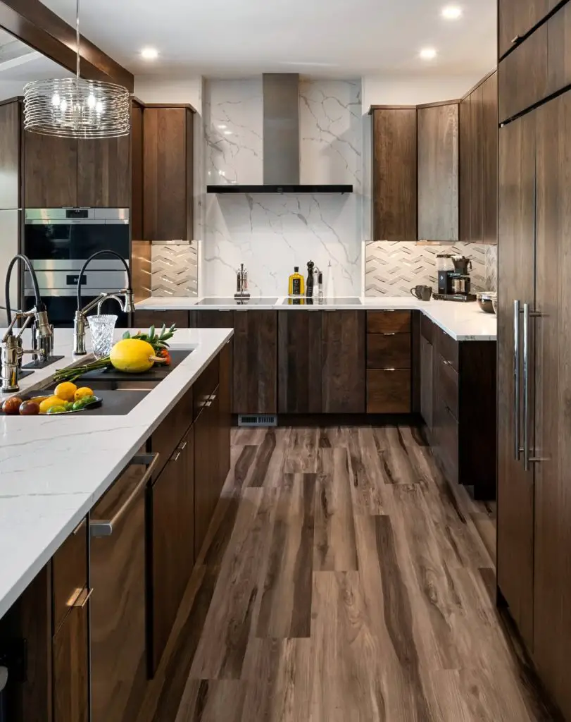 Contemporary kitchen with dark wood cabinets, marble countertops, and a chevron tile backsplash