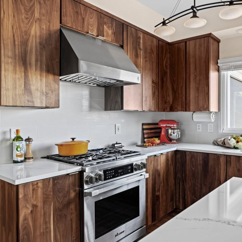 Contemporary kitchen with walnut cabinets, stainless steel appliances, and a white countertop